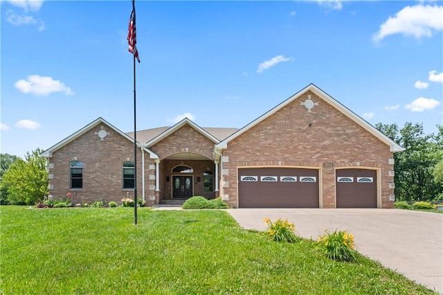 31134 W 161st St, Excelsior Springs, MO 64024 - view of front of house featuring a front lawn, concrete driveway, a garage, french doors, and brick siding