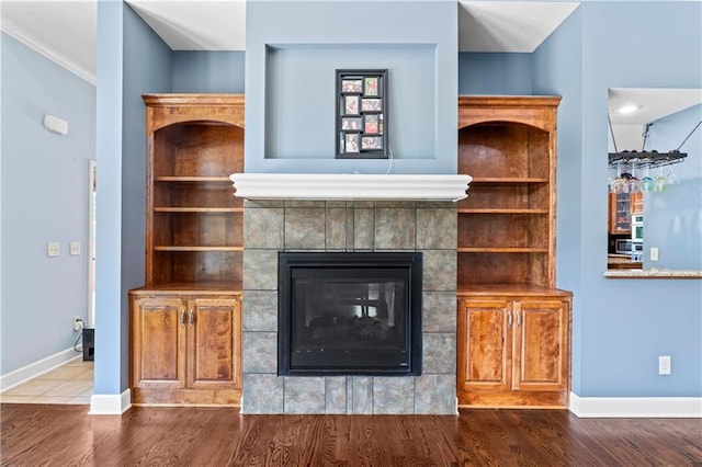 31134 W 161st St, Excelsior Springs, MO 64024 - unfurnished living room with wood finished floors, a tiled fireplace, and ornamental molding