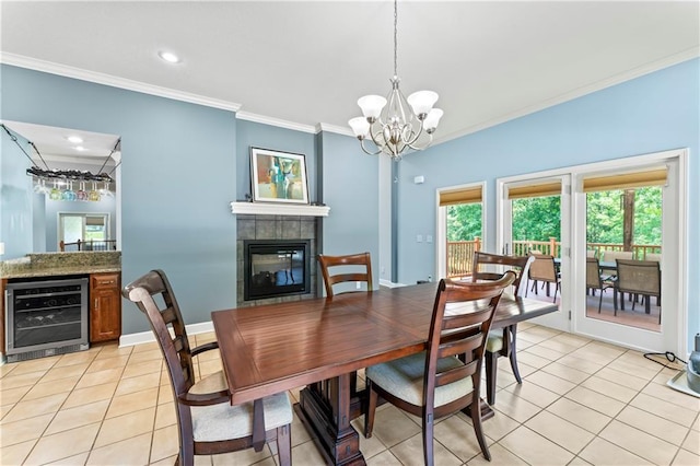 31134 W 161st St, Excelsior Springs, MO 64024 - dining space featuring beverage cooler, crown molding, light tile patterned floors, a fireplace, and a chandelier