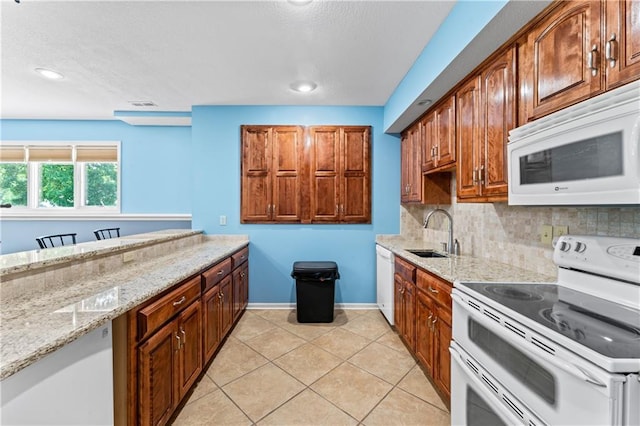 31134 W 161st St, Excelsior Springs, MO 64024 - kitchen with white appliances, tasteful backsplash, light stone counters, light tile patterned floors, and recessed lighting