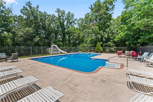31134 W 161st St, Excelsior Springs, MO 64024 - view of pool with a water slide, a patio area, view of wooded area, and a diving board