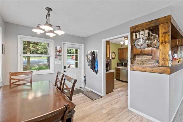 321 W Sugarlake Dr, Mound City, KS 66056 - dining area featuring a chandelier, light wood finished floors, and a textured ceiling