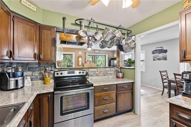 321 W Sugarlake Dr, Mound City, KS 66056 - kitchen with stainless steel electric stove, ceiling fan, backsplash, and light stone counters