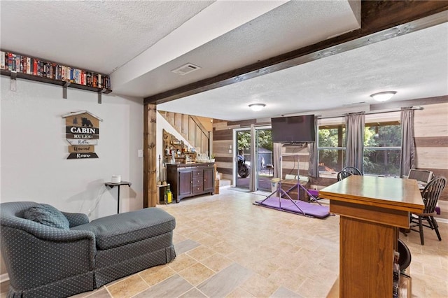 321 W Sugarlake Dr, Mound City, KS 66056 - living room with a textured ceiling, wooden walls, stairway, and light stone finish flooring