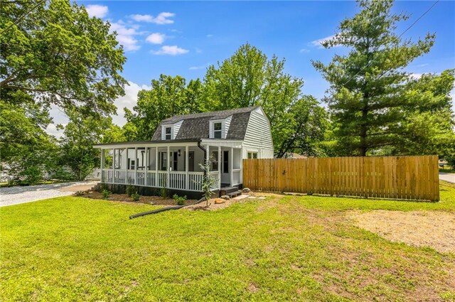 8801 E 49th St, Kansas City, MO 64129 - back of house featuring a gambrel roof, a porch, and a shingled roof