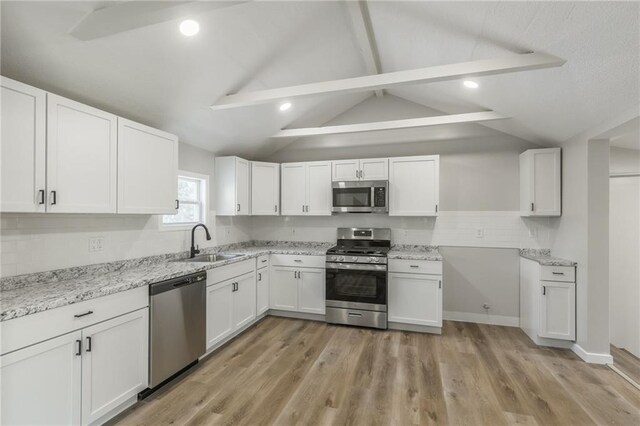 8801 E 49th St, Kansas City, MO 64129 - kitchen with appliances with stainless steel finishes, white cabinets, light stone countertops, light wood-type flooring, and recessed lighting