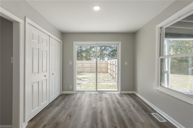 8801 E 49th St, Kansas City, MO 64129 - unfurnished bedroom with wood finished floors, a closet, recessed lighting, and access to outside