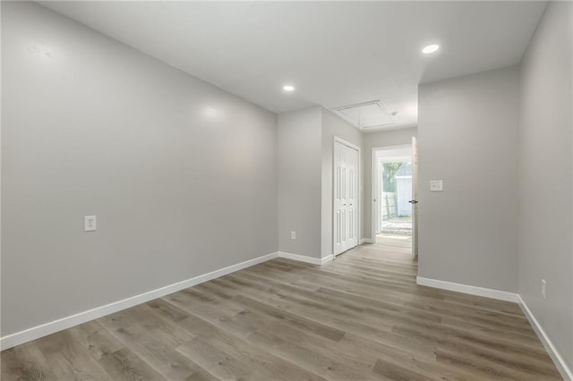 8801 E 49th St, Kansas City, MO 64129 - spare room with attic access, wood finished floors, and recessed lighting