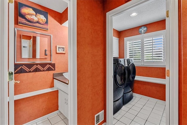 4328 W 110th St, Leawood, KS 66211 - laundry area with light tile patterned floors, washer and dryer, cabinet space, light colored carpet, and a textured ceiling
