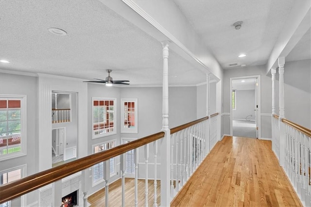 4328 W 110th St, Leawood, KS 66211 - hallway with wood finished floors, a textured ceiling, recessed lighting, and an upstairs landing