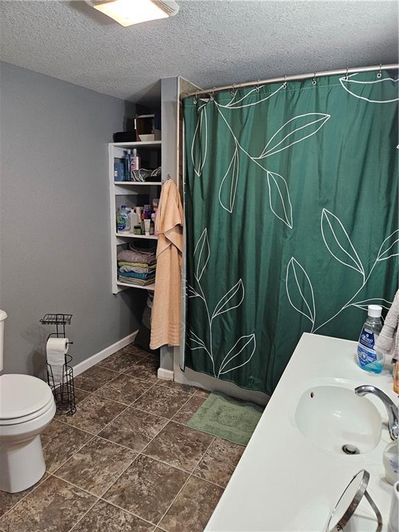 245 S 250th St, Pittsburg, KS 66762 - bathroom with a textured ceiling, a shower with shower curtain, and vanity