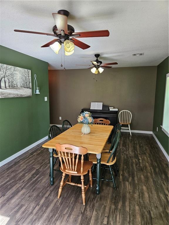 245 S 250th St, Pittsburg, KS 66762 - dining room featuring wood finished floors, a ceiling fan, and a textured ceiling
