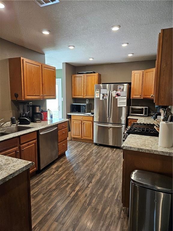 245 S 250th St, Pittsburg, KS 66762 - kitchen featuring appliances with stainless steel finishes, dark wood-style flooring, recessed lighting, a textured ceiling, and brown cabinetry