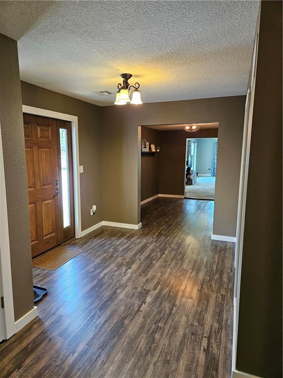 245 S 250th St, Pittsburg, KS 66762 - entryway featuring dark wood-type flooring, a textured ceiling, and a chandelier