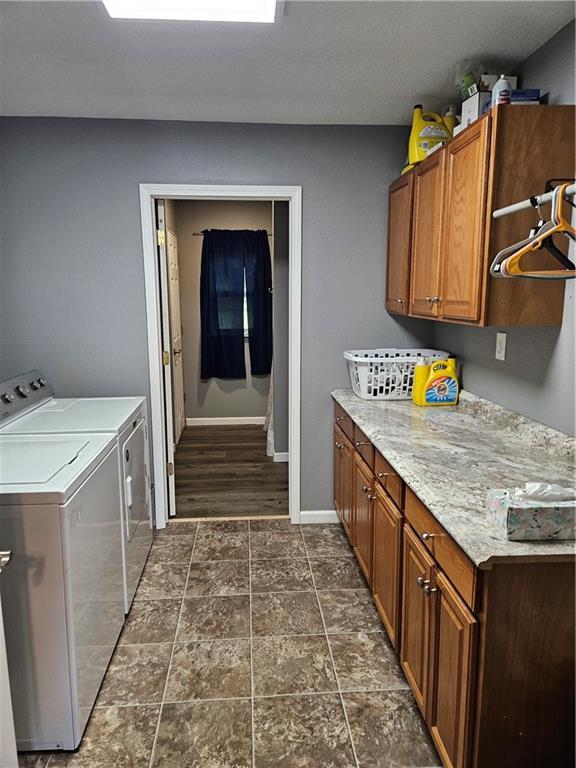 245 S 250th St, Pittsburg, KS 66762 - laundry room with cabinet space, washer and dryer, and dark stone finish floors
