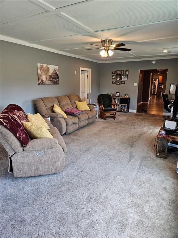 245 S 250th St, Pittsburg, KS 66762 - carpeted living area featuring baseboards and ceiling fan