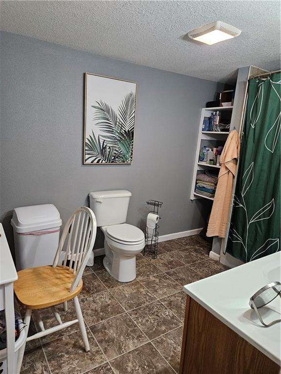245 S 250th St, Pittsburg, KS 66762 - bathroom featuring vanity, a textured ceiling, and curtained shower