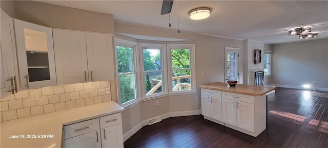 8738 Horton St, Overland Park, KS 66207 - kitchen with dark wood finished floors, open floor plan, white cabinetry, glass insert cabinets, and tasteful backsplash