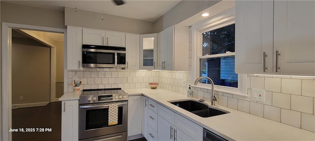 8738 Horton St, Overland Park, KS 66207 - kitchen with appliances with stainless steel finishes, white cabinets, light countertops, decorative backsplash, and recessed lighting