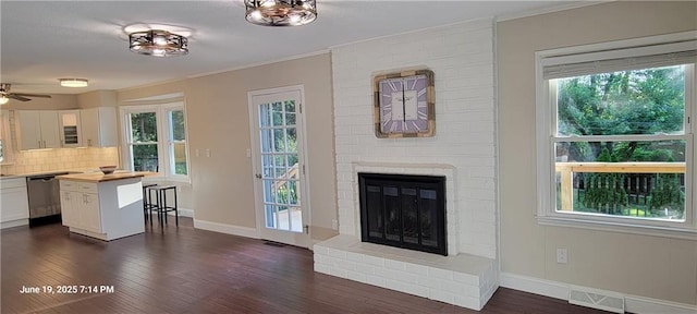 8738 Horton St, Overland Park, KS 66207 - living room with ornamental molding, dark wood finished floors, a brick fireplace, and a ceiling fan
