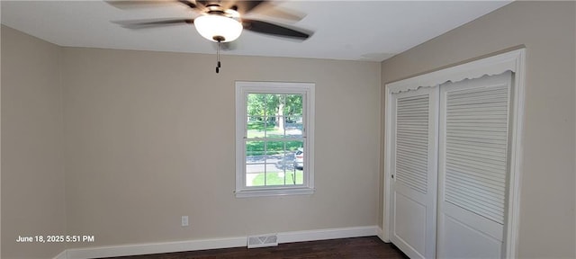 8738 Horton St, Overland Park, KS 66207 - unfurnished bedroom with dark wood-style floors, multiple windows, a closet, and a ceiling fan
