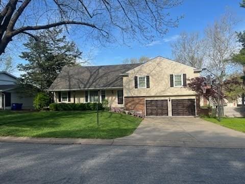 8738 Horton St, Overland Park, KS 66207 - split level home featuring an attached garage, driveway, and a front yard