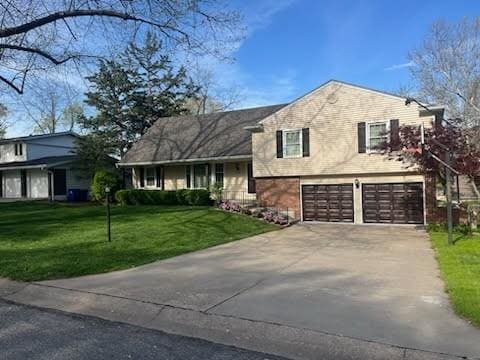 8738 Horton St, Overland Park, KS 66207 - split level home featuring a garage, driveway, and a front lawn