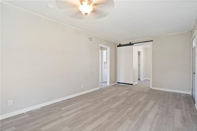15309 E Mayes Rd, Independence, MO 64050 - unfurnished bedroom featuring light wood-style flooring, crown molding, a barn door, and ceiling fan
