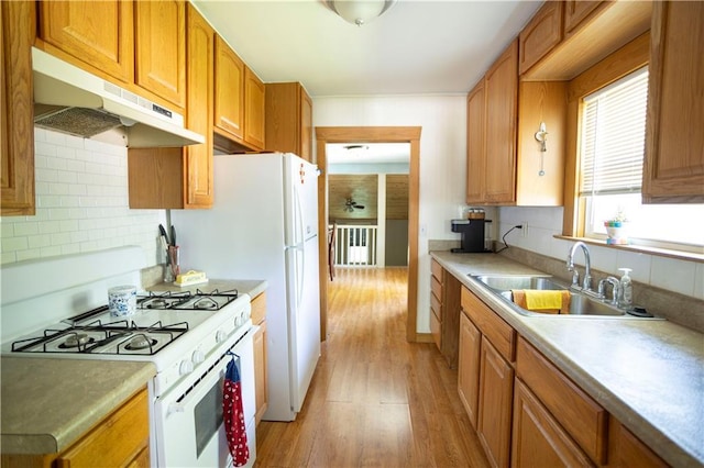 1619 W College St, Independence, MO 64050 - kitchen featuring white gas range oven, under cabinet range hood, light wood-style floors, decorative backsplash, and brown cabinetry
