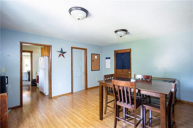 1619 W College St, Independence, MO 64050 - dining space featuring light wood-style floors and a textured ceiling
