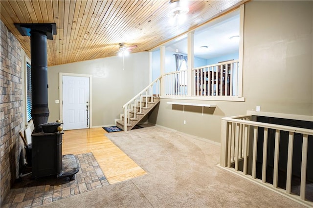 1619 W College St, Independence, MO 64050 - entrance foyer with a wood stove, wood ceiling, carpet, stairway, and ceiling fan