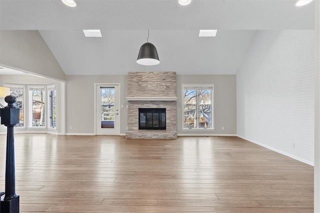 11412 Foster St, Overland Park, KS 66210 - unfurnished living room featuring healthy amount of natural light, wood-type flooring, a stone fireplace, and high vaulted ceiling