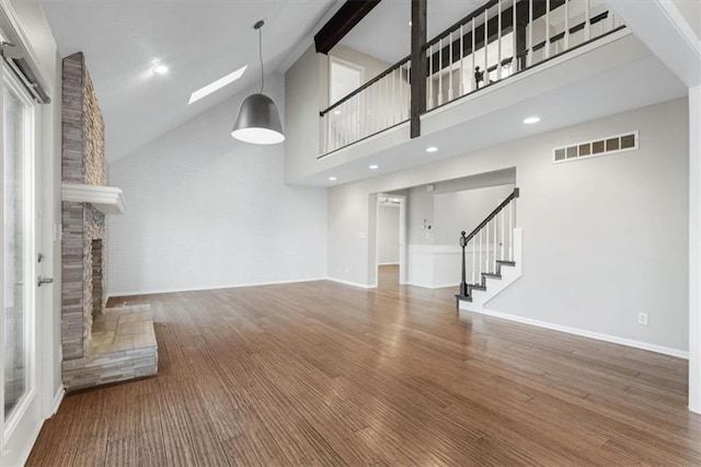 11412 Foster St, Overland Park, KS 66210 - unfurnished living room with high vaulted ceiling, stairway, a fireplace with raised hearth, wood finished floors, and beamed ceiling