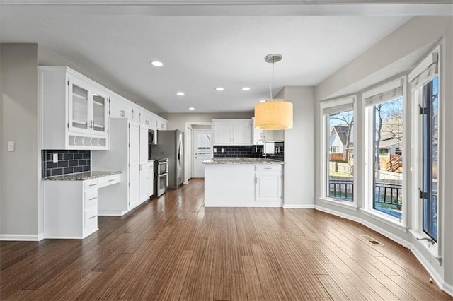 11412 Foster St, Overland Park, KS 66210 - kitchen featuring decorative backsplash, dark wood-style flooring, stainless steel appliances, white cabinets, and glass insert cabinets