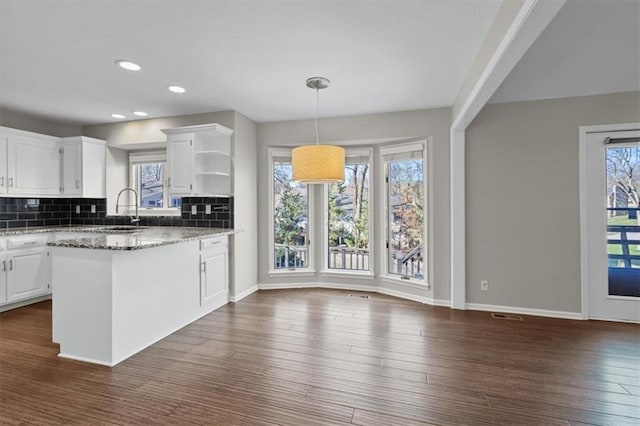 11412 Foster St, Overland Park, KS 66210 - kitchen with open shelves, white cabinetry, backsplash, dark wood finished floors, and hanging light fixtures