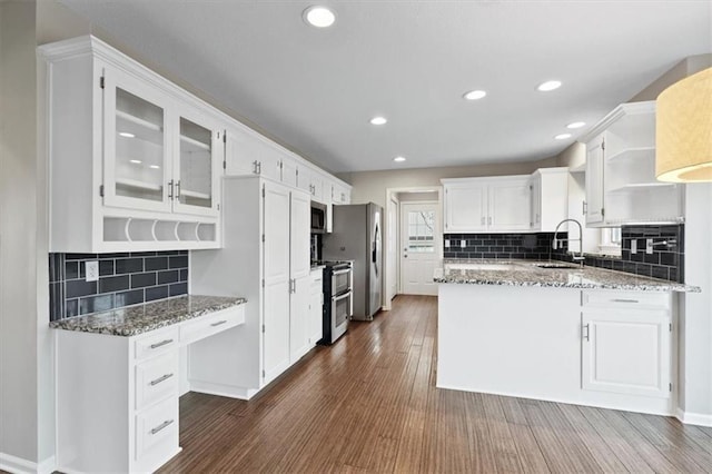 11412 Foster St, Overland Park, KS 66210 - kitchen featuring stainless steel appliances, white cabinets, dark wood finished floors, a peninsula, and light stone counters
