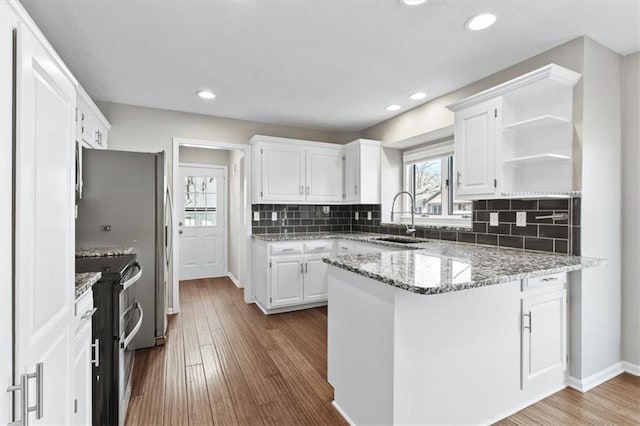 11412 Foster St, Overland Park, KS 66210 - kitchen featuring double oven range, a peninsula, open shelves, healthy amount of natural light, and recessed lighting