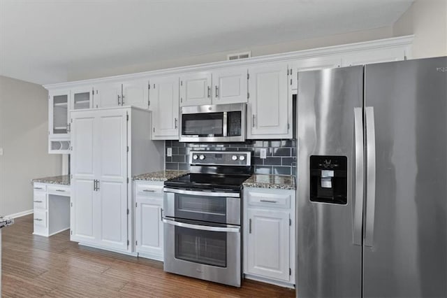 11412 Foster St, Overland Park, KS 66210 - kitchen with stainless steel appliances, light stone countertops, and white cabinetry