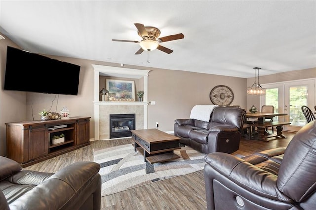 12318 N Wayne Ave, Kansas City, MO 64165 - living area with wood finished floors, ceiling fan, a tiled fireplace, and french doors