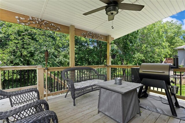 12318 N Wayne Ave, Kansas City, MO 64165 - wooden deck with a ceiling fan, an outdoor living space, and view of wooded area