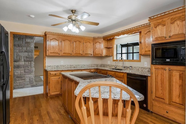 18209 E Moorland St, Pleasant Hill, MO 64080 - kitchen with black appliances, dark wood-type flooring, ceiling fan, and brown cabinetry