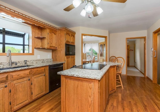 18209 E Moorland St, Pleasant Hill, MO 64080 - kitchen featuring black appliances, a center island, wood finished floors, ceiling fan, and brown cabinets