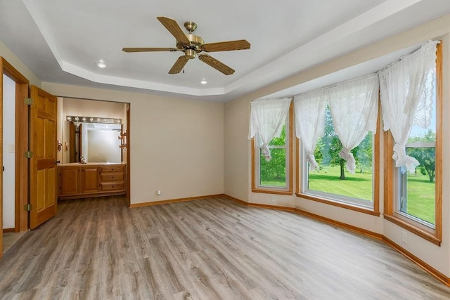 18209 E Moorland St, Pleasant Hill, MO 64080 - empty room with a raised ceiling, light wood-style flooring, healthy amount of natural light, and ceiling fan