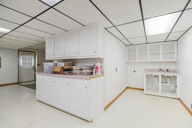 18209 E Moorland St, Pleasant Hill, MO 64080 - kitchen with light flooring, open shelves, a paneled ceiling, white cabinetry, and light countertops
