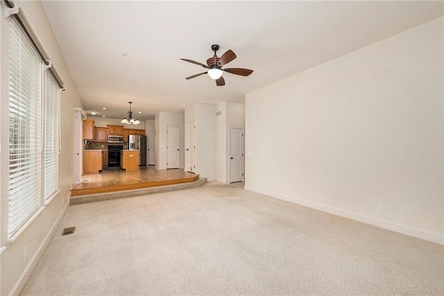 1905 160th St, Basehor, KS 66007 - unfurnished living room with a chandelier, light colored carpet, and plenty of natural light
