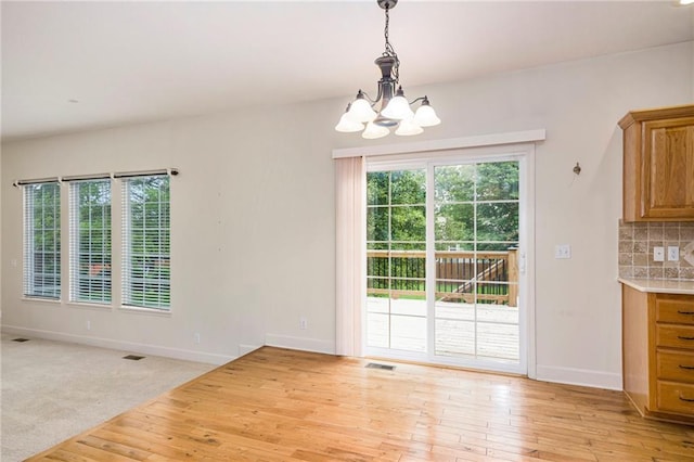 1905 160th St, Basehor, KS 66007 - unfurnished dining area featuring a chandelier, plenty of natural light, and light wood-style flooring