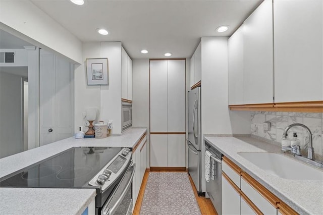 5137 W 75th St, Prairie Village, KS 66208 - kitchen with stainless steel appliances, light countertops, recessed lighting, backsplash, and white cabinets