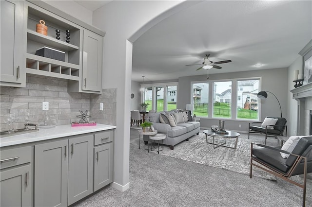 6102 Lewis Dr, Shawnee, KS 66226 - living area featuring arched walkways, light carpet, and ceiling fan