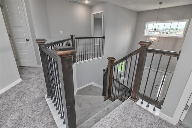 6102 Lewis Dr, Shawnee, KS 66226 - stairway featuring carpet flooring and a chandelier