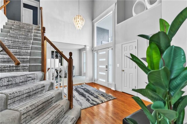 8007 W 131st Ter, Overland Park, KS 66213 - foyer entrance featuring stairway, a towering ceiling, wood finished floors, and a chandelier